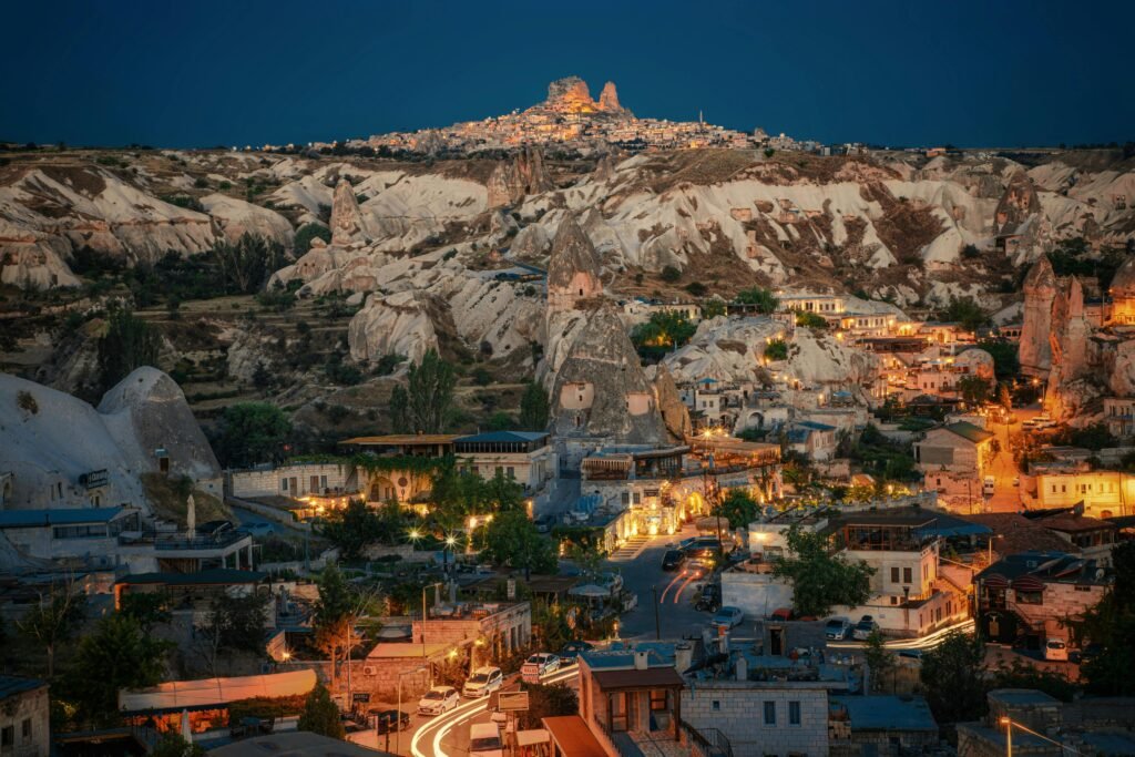 Stunning night view of Göreme in Cappadocia, Turkey, showcasing unique rock formations and lit streets.