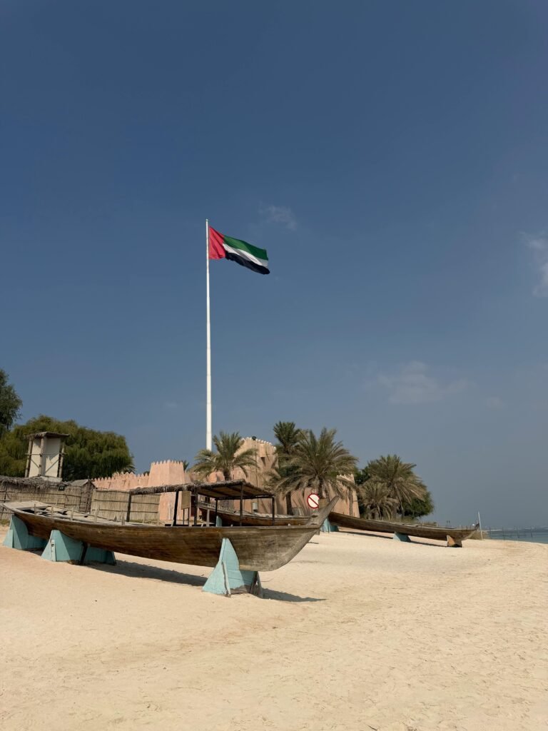Émirats Arabes Unis — Entre gratte-ciels délirants et désert infini Scenic view of traditional boats and UAE flag on a beach in Abu Dhabi, United Arab Emirates.